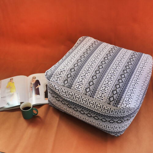 Pouf squadrato con stampa geometrica nera e bianca, con rivista e tazza