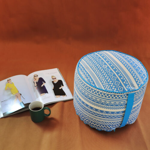 Pouf tondo con fantasia geometrica blu, rivista e tazza