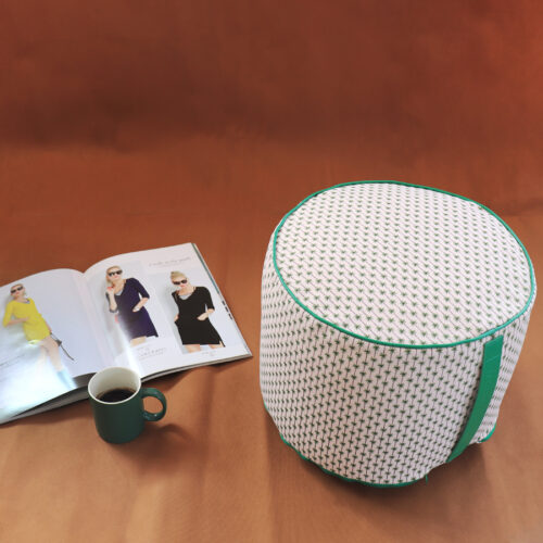 Pouf tondo con stampa palme su fondo bianco, più rivista e tazza